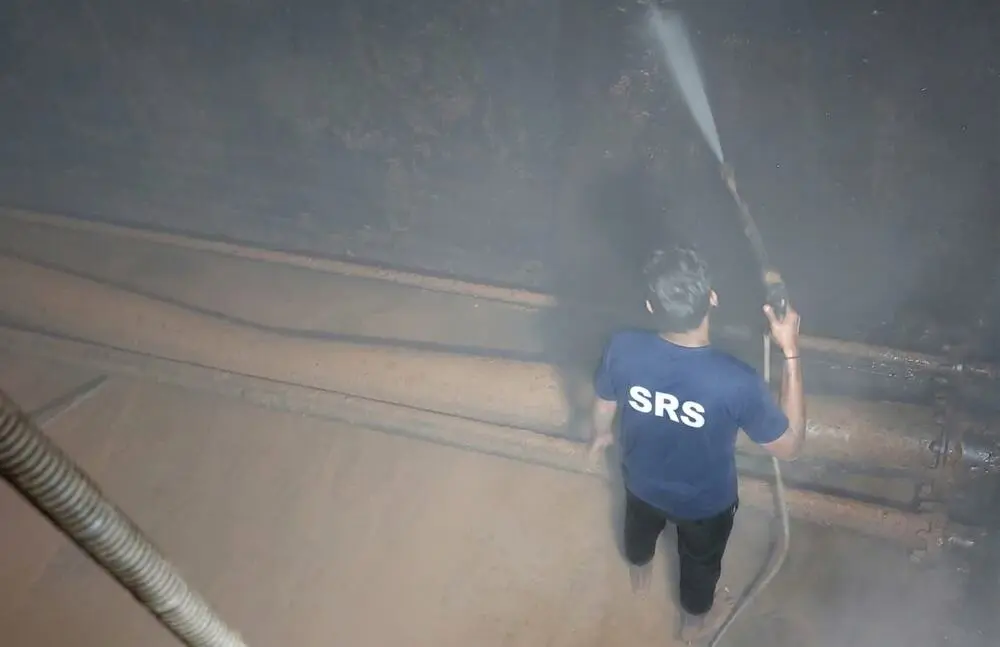 Technician jet-washing the interior wall of a large water tank