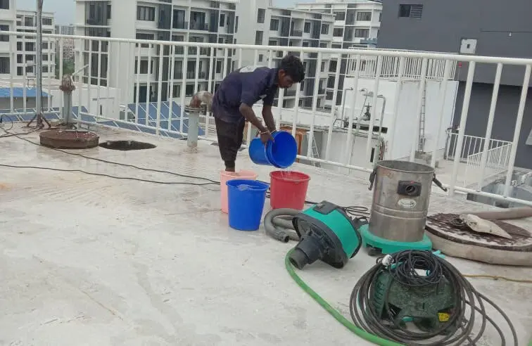 Technician staging vacuum and pump equipment on a rooftop