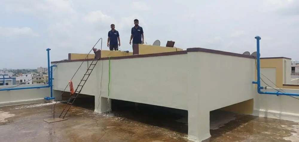Top of a rooftop overhead water tank after cleaning, two technicians on site