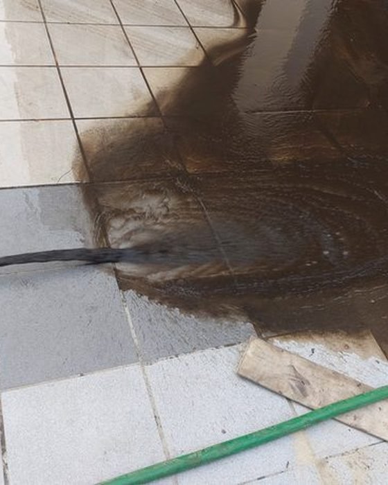 Muddy sludge water being drained out during tank cleaning in Kalighat, Kolkata