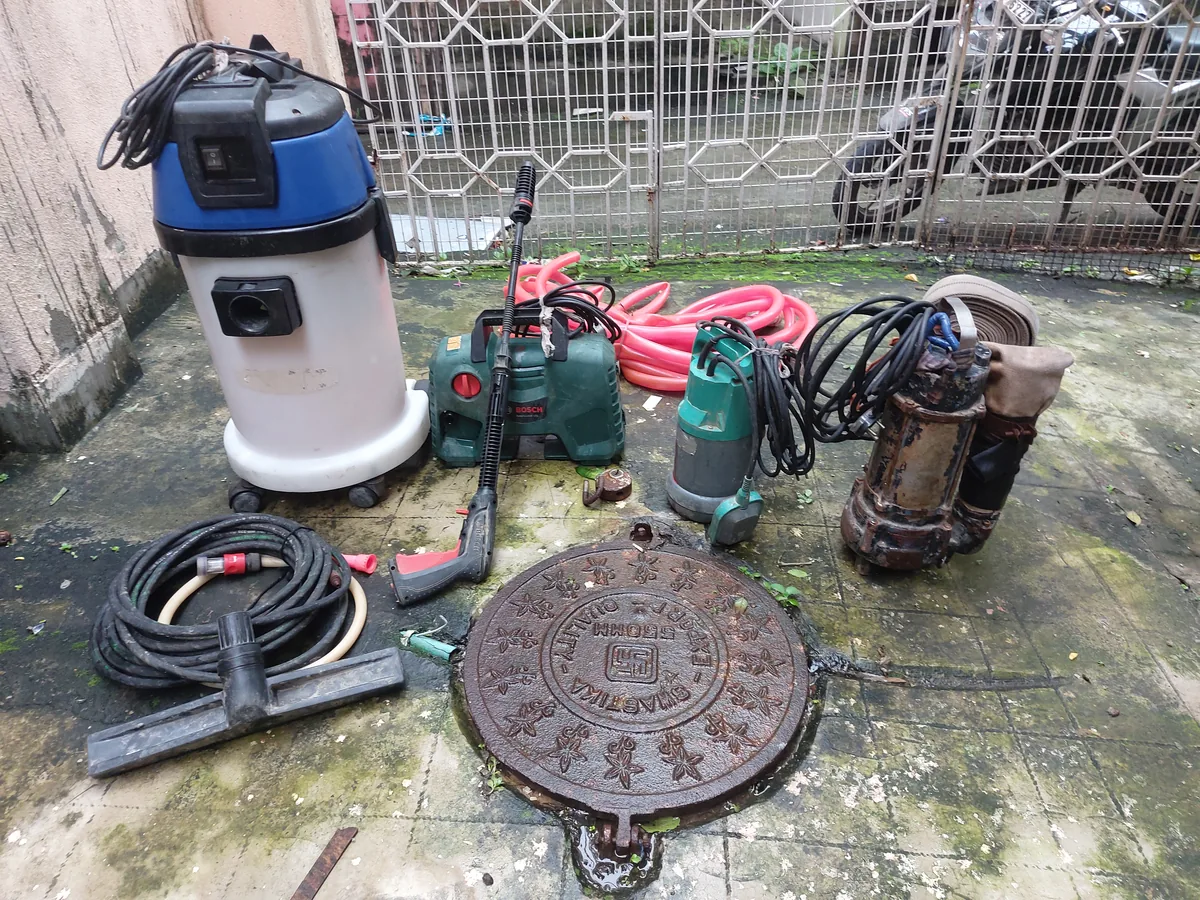 SRS mechanized tank cleaning equipment laid out before a job — vacuum, pressure washer and submersible pumps