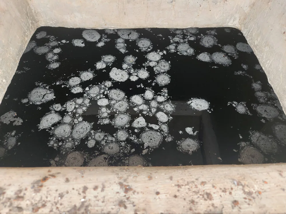 Thick sediment and sludge settled at the bottom of a water tank