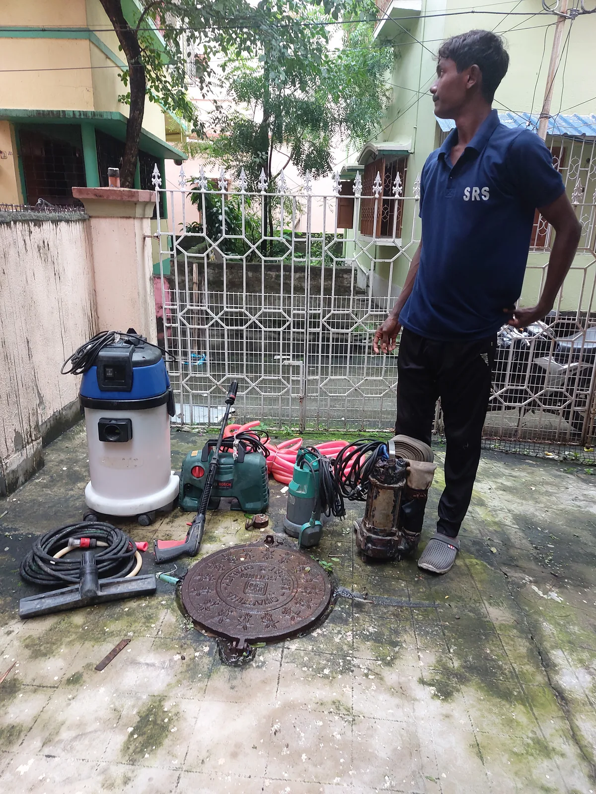 SRS-uniformed technician standing beside cleaning equipment on-site